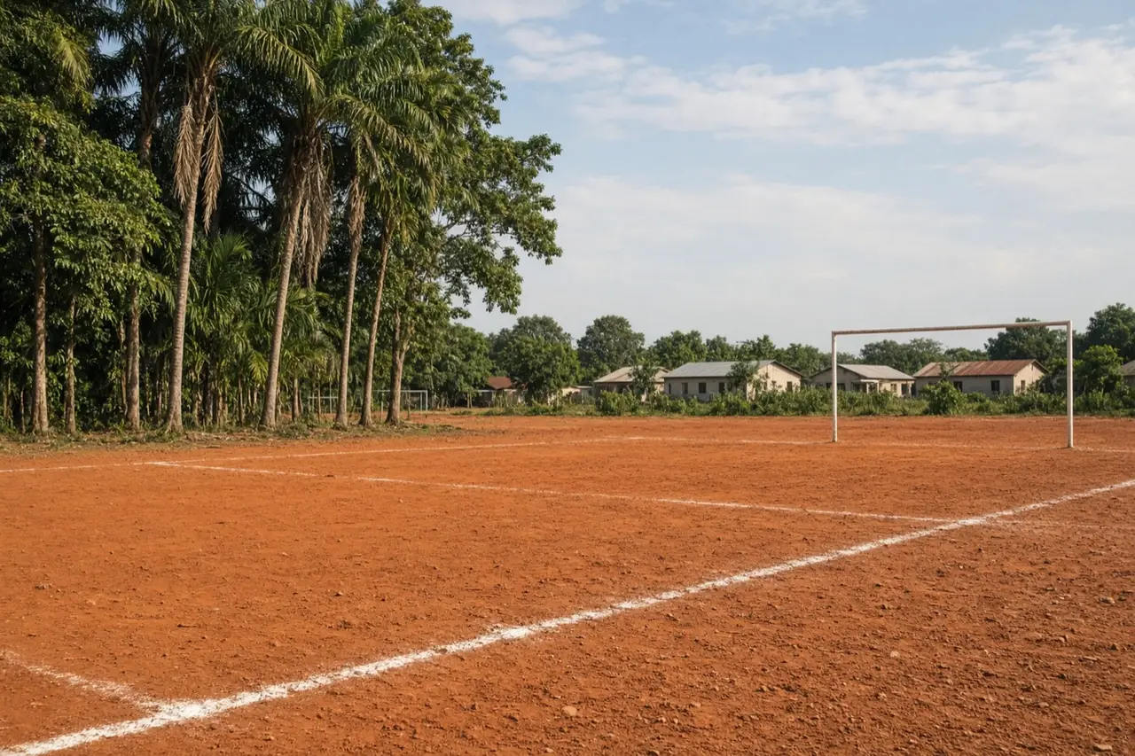 Terrain de football en terre battue bordé de palmiers