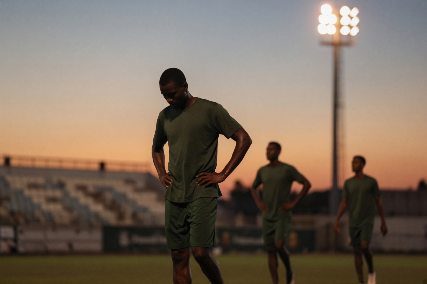Joueurs &agrave; l'entra&icirc;nement sur un terrain au cr&eacute;puscule